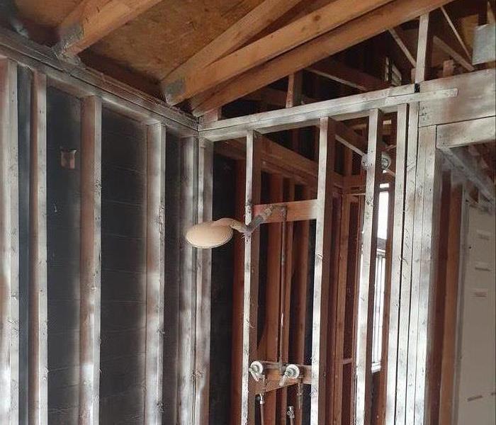 A room without walls or insulation. Showing framing and plumbing. 
