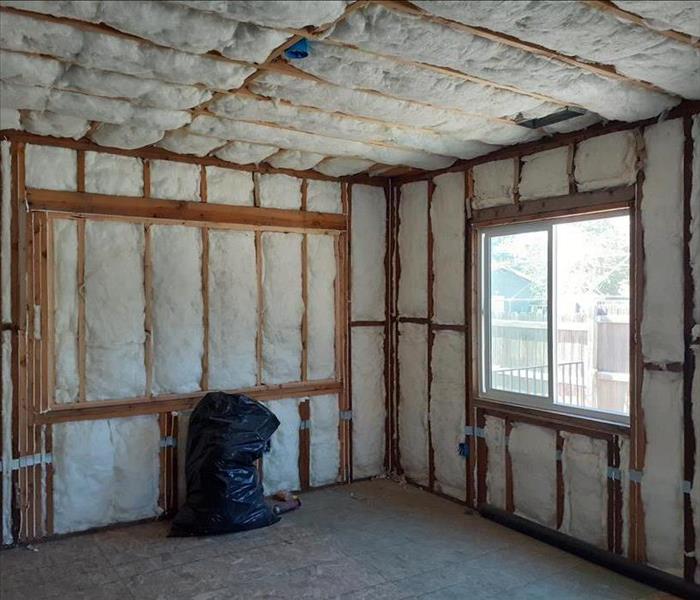 A room with out walls showing framing and white insulation. 